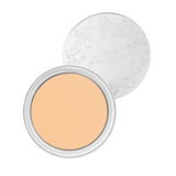 A compact of 100% Pure Cream Foundation 9g sits open, revealing smooth, pale beige vegan powder. Behind it is a silver lid embossed with a floral design and the words "100% Pure.