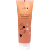 A tube of 100% Pure Glossy Locks Multi-Vitamin Healthy Hair Shampoo with black text and botanical illustrations on an orange-pink background, featuring a white flip-top cap—perfect as a nourishing biotin shampoo for healthy hair.