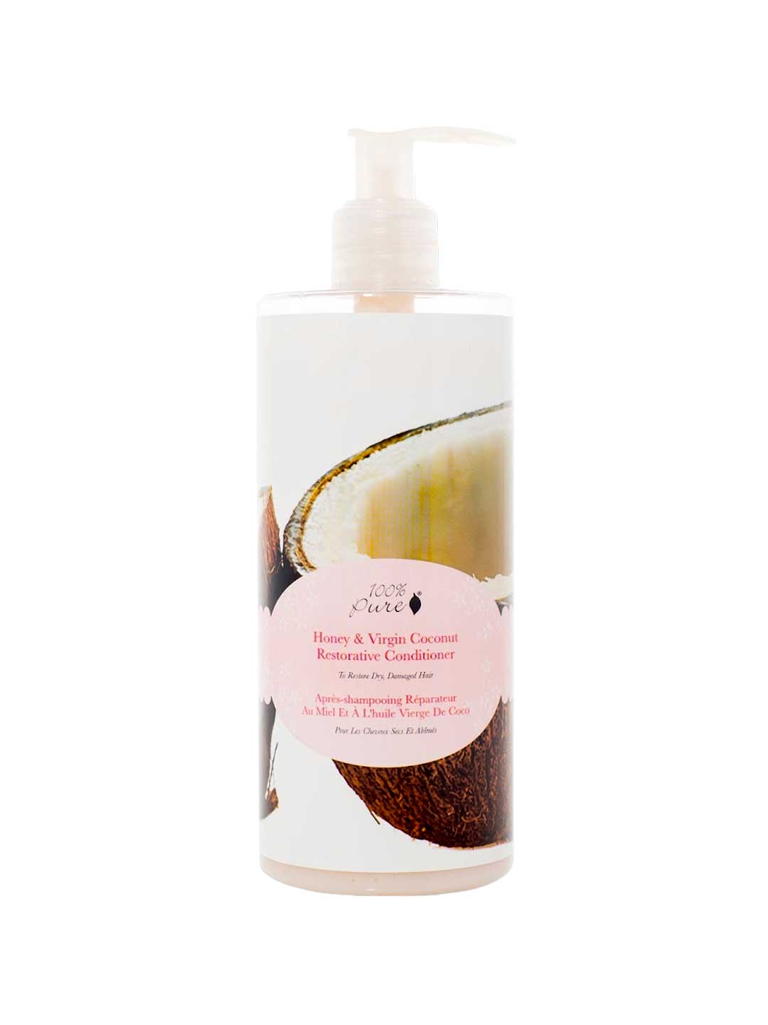 A pump bottle of 100% Pure Honey & Virgin Coconut Restorative Conditioner by 100% Pure, sulfate-free, with pink-accented labeling and cracked coconut imagery on the packaging.