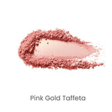 A smear of 100% Pure Fruit Pigmented® Gemmed Luminiser 9g in shimmery pink-gold rests on a white background, labeled “Pink Gold Taffeta” beneath the swatch.