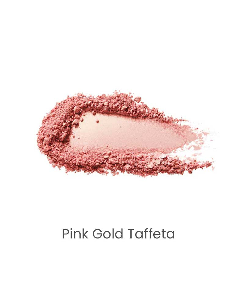 A smear of 100% Pure Fruit Pigmented® Gemmed Luminiser 9g in shimmery pink-gold rests on a white background, labeled “Pink Gold Taffeta” beneath the swatch.