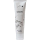 A white tube of 100% Pure Fermented Rice Water Cleanser 100ml, featuring minimalist black text and a rice stalk illustration, stands upright on a white background—ideal for brightening and targeting hyperpigmentation.