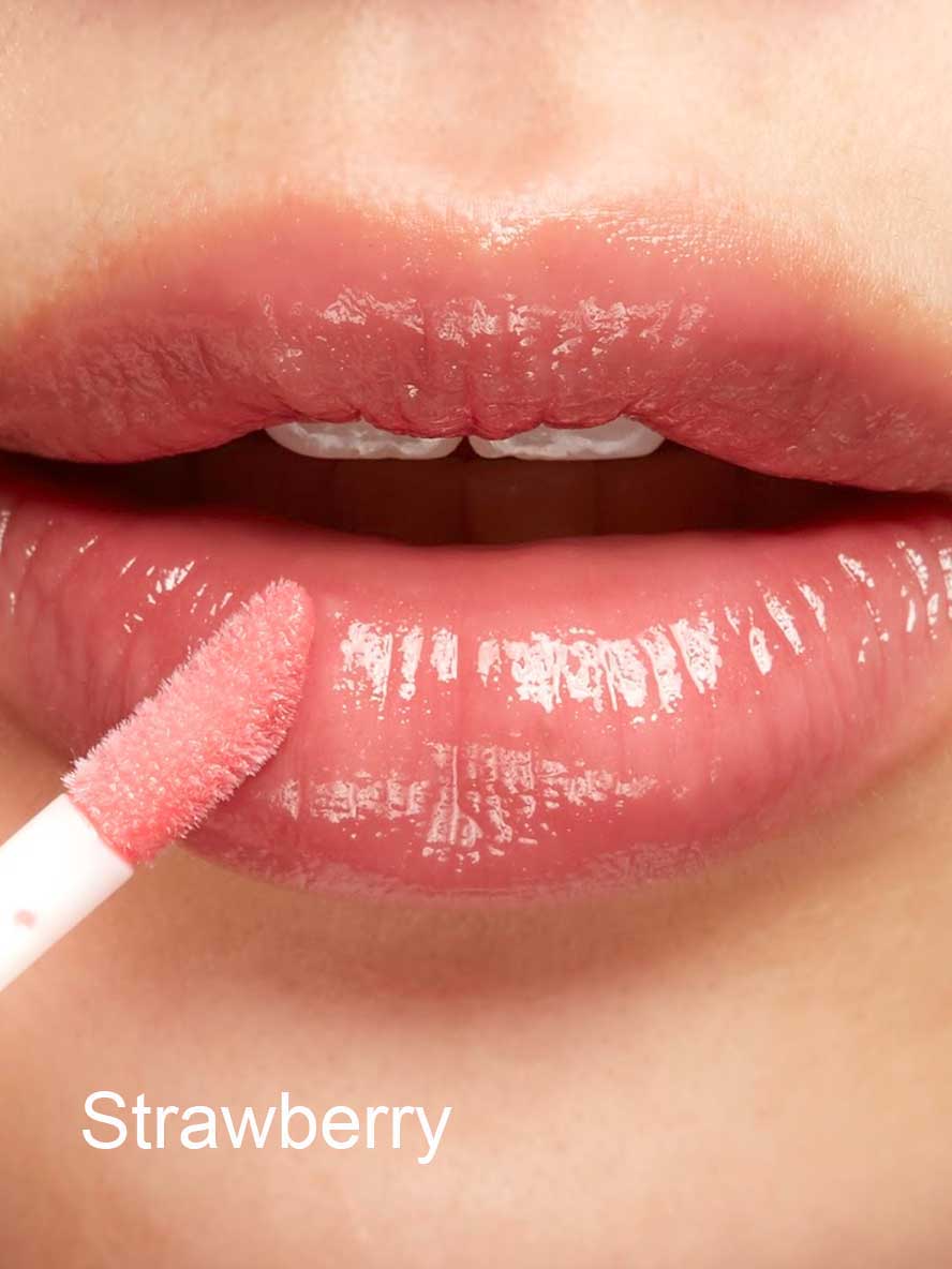 Close-up of glossy lips being coated with 100% Pure Lip Gloss, an ultra shiny formula infused with pomegranate oil, applied with a wand. The word "Strawberry" appears in white text at the bottom left corner.