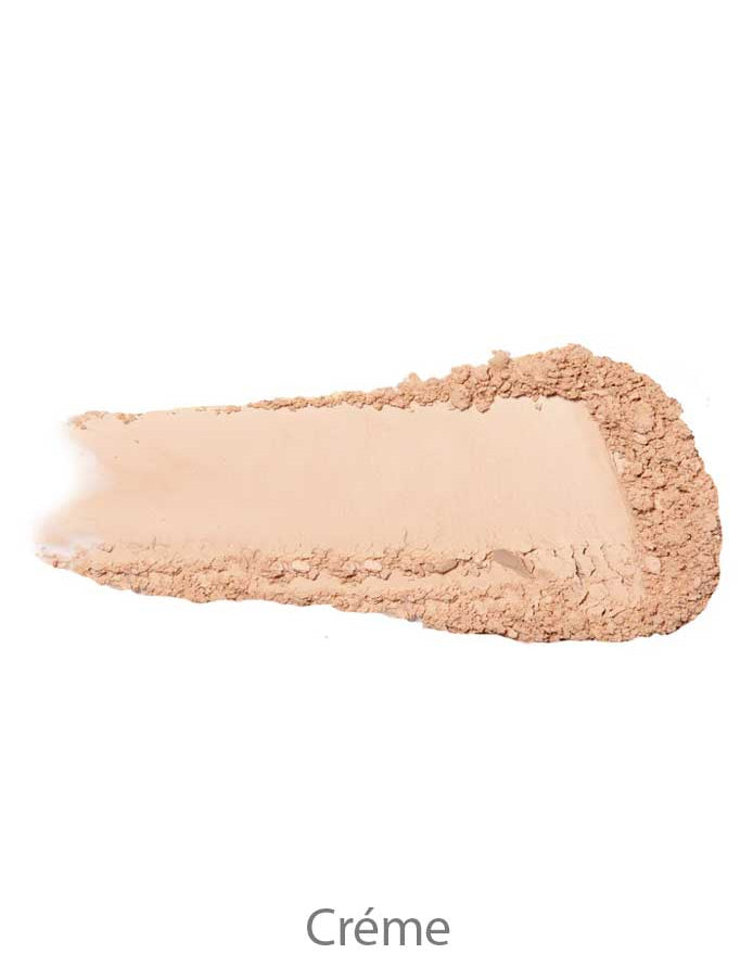 A swatch of 100% Pure Rice Powder Foundation 9g in light beige is smeared on a white background with “Crème” written below. The vegan powder’s smooth texture has slightly crumbled edges.