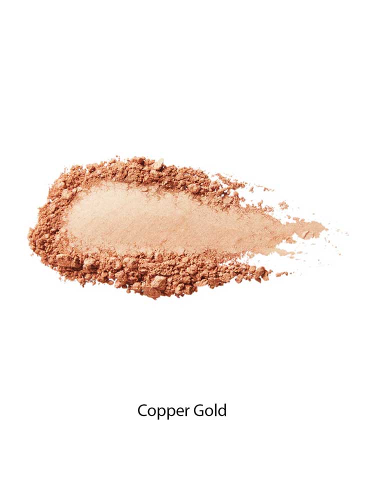 A swatch of 100% Pure Gemmed Luminiser 9g in a warm copper gold shade is spread on a white background, perfect for a natural glow. The text "Copper Gold" appears below the makeup sample.