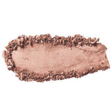A close-up of 100% Pure Pressed Eye Shadow 2g by 100% Pure in light brown/beige, showing smudged and crumbled vegan powder with mineral shimmer scattered on a white background.