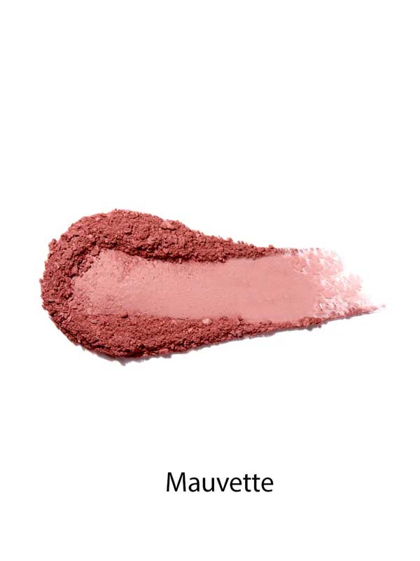 A swatch of mauve-pink 100% Pure Rice Powder Pressed Blush 9g is smeared on a white background, showing its buildable coverage for a natural flush. The word "Mauvette" appears below.
