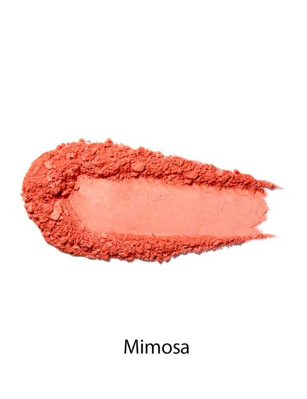 A swatch of 100% Pure Rice Powder Pressed Blush 9g in peachy coral Mimosa is displayed on a white background, showcasing its natural flush and buildable coverage.