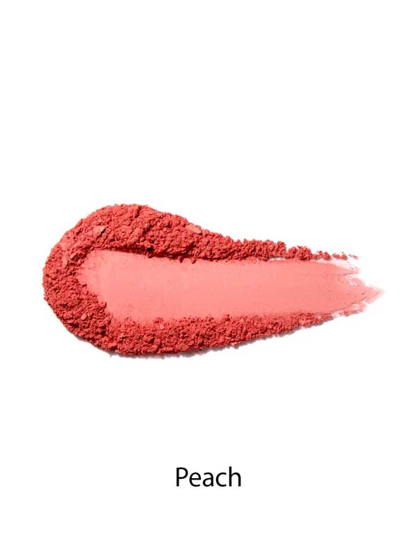 A smear of 100% Pure Rice Powder Pressed Blush 9g in peach on a white background, with "Peach" below, highlights its buildable coverage for a natural-looking flush.