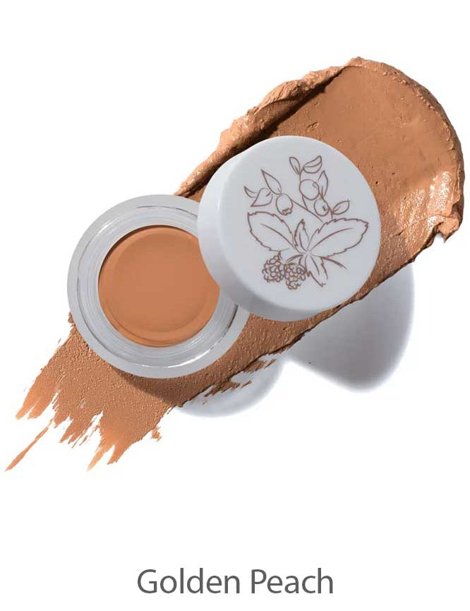 An open jar of 100% Pure Long Last Concealer 3g in a golden peach shade sits on a matching swatch, its lid adorned with a floral illustration. The text "Golden Peach" appears below.