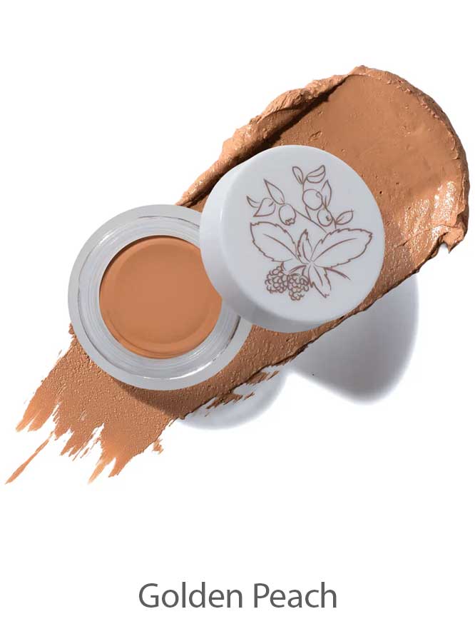 An open jar of 100% Pure Long Last Concealer 3g in a golden peach shade sits on a matching swatch, its lid adorned with a floral illustration. The text "Golden Peach" appears below.