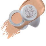 The 100% Pure Long Last Concealer comes in a small jar with a floral design on its white lid, shown alongside a peach-colored, full coverage swatch labeled White Peach.