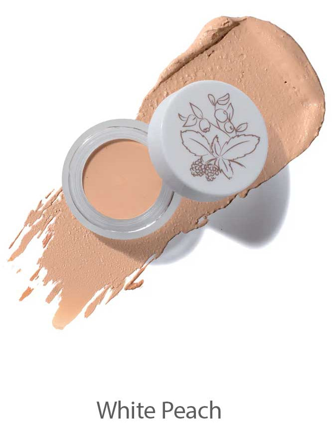 The 100% Pure Long Last Concealer comes in a small jar with a floral design on its white lid, shown alongside a peach-colored, full coverage swatch labeled White Peach.