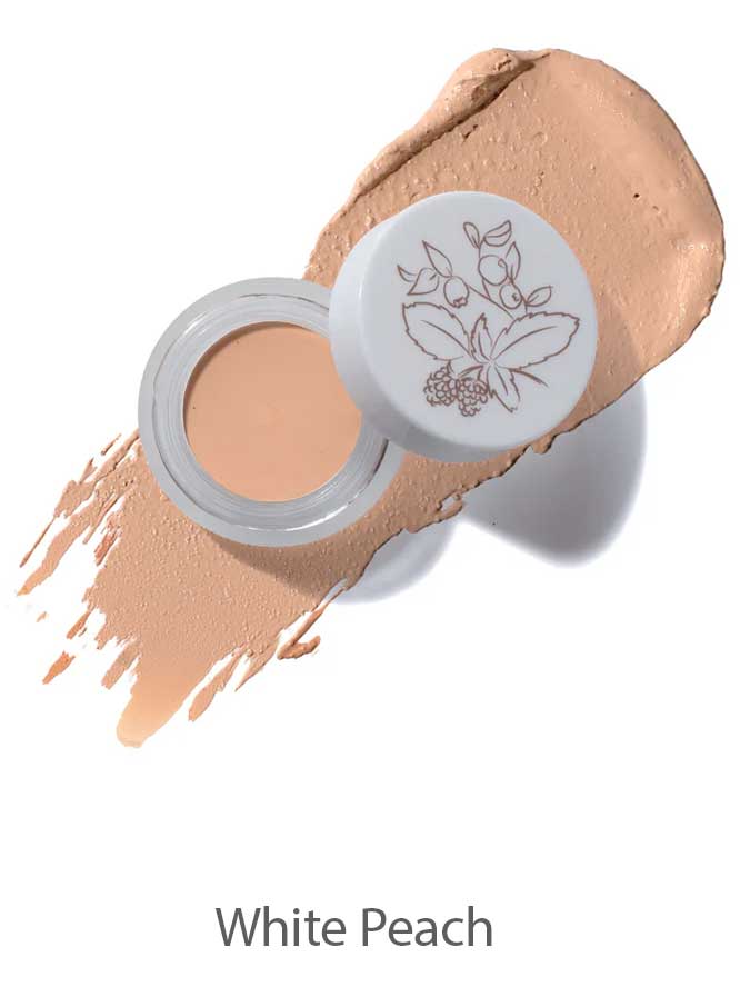 The 100% Pure Long Last Concealer comes in a small jar with a floral design on its white lid, shown alongside a peach-colored, full coverage swatch labeled White Peach.