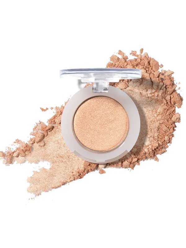 An open compact of 100% Pure Pressed Eye Shadow 2g by 100% Pure in shimmery beige, with a light dusting of powder around it on a white background.